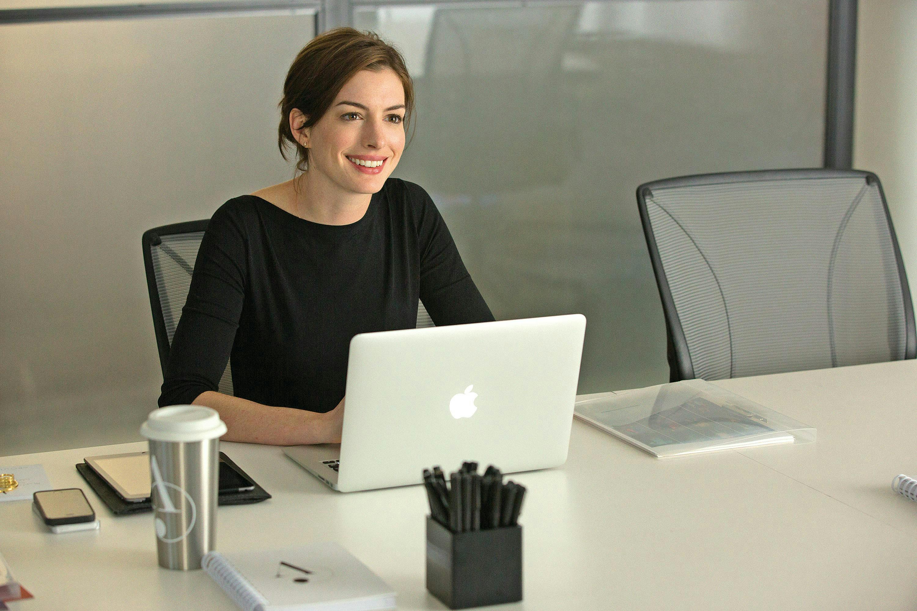 jules ostin-anne hathaway pc computer electronics furniture person human sitting laptop table desk