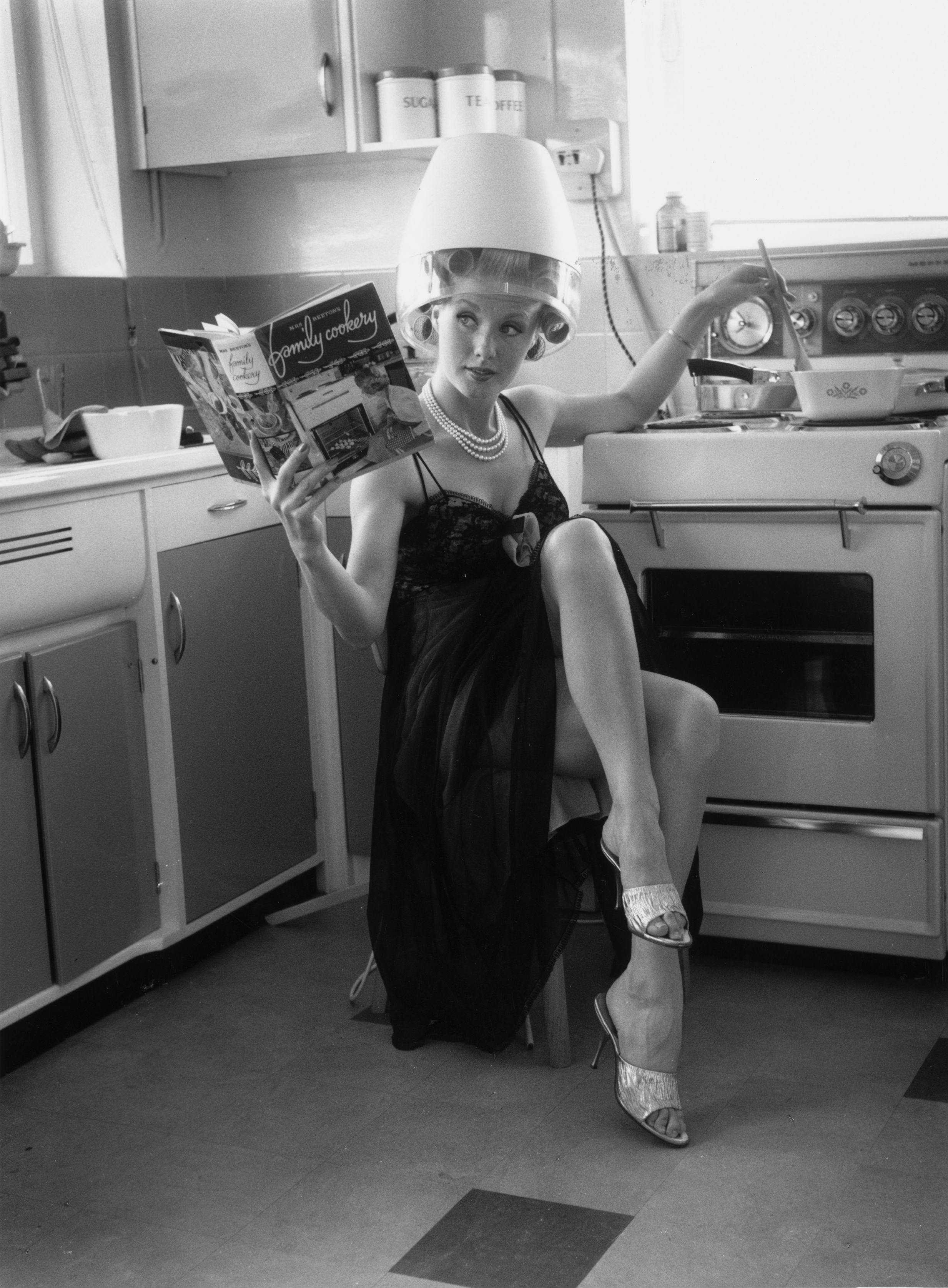 black & white;format portrait;female;hairdryer;domestic applianc helmet clothing person human room indoors oven appliance interior design female